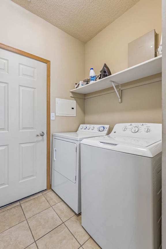 partment laundry room with full-size washer and dryer, shelving, and additional storage space.