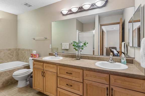 A bathroom with a white toilet and dual sinks