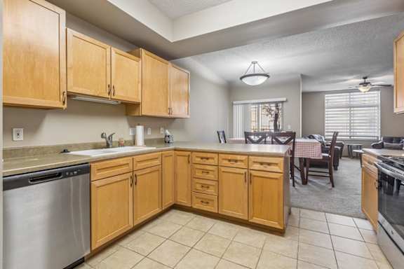 Open apartment kitchen with light wood cabinets, tile flooring, ample counter space, and adjacent dining area.