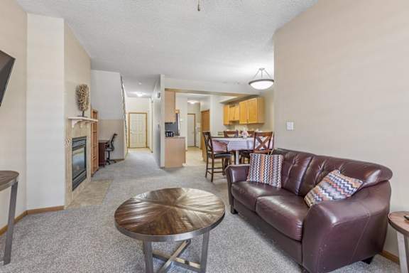 Open apartment kitchen with light wood cabinets, tile flooring, ample counter space, and adjacent dining area.