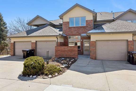 Exterior view of townhome building with private garages and shared driveway.