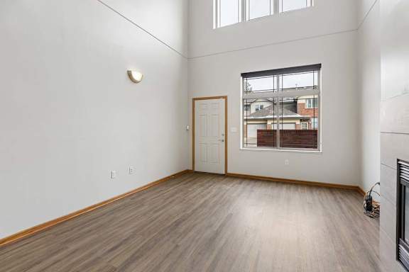 Bright living room featuring vaulted ceilings and plank flooring.