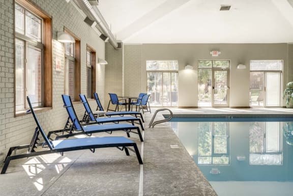 a swimming pool with blue lounge chairs