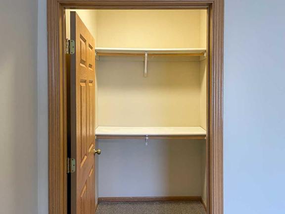 a walk-in closet with two built-in shelves and hanging space