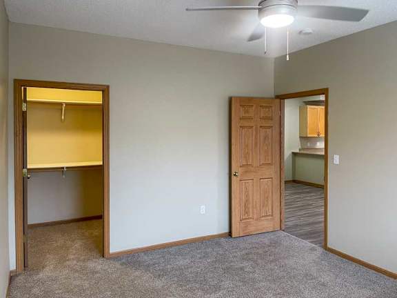 a bedroom with a ceiling fan and a walk-in closet