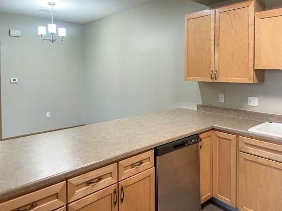 a kitchen with wooden cabinets and stainless steel appliances