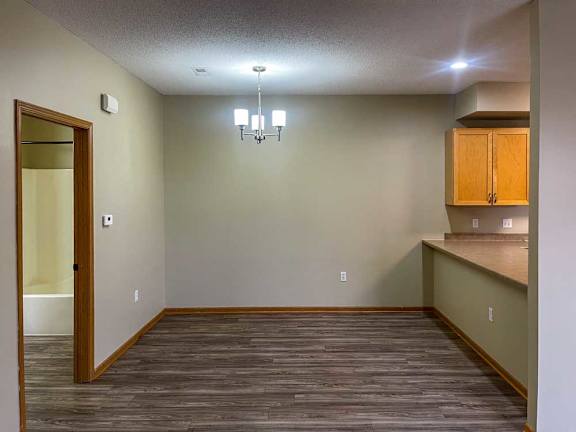 a dining room with wooden flooring and hanging light fixture