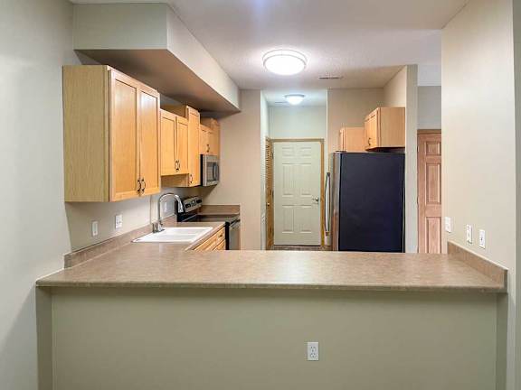 a kitchen with wooden cabinets and stainless steel appliances