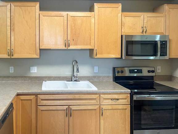 a kitchen with wooden cabinets and a stainless steel appliances
