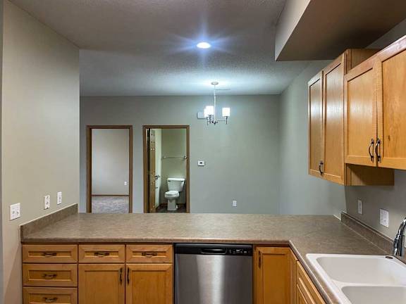 a kitchen with wooden cabinets in front of a dining area