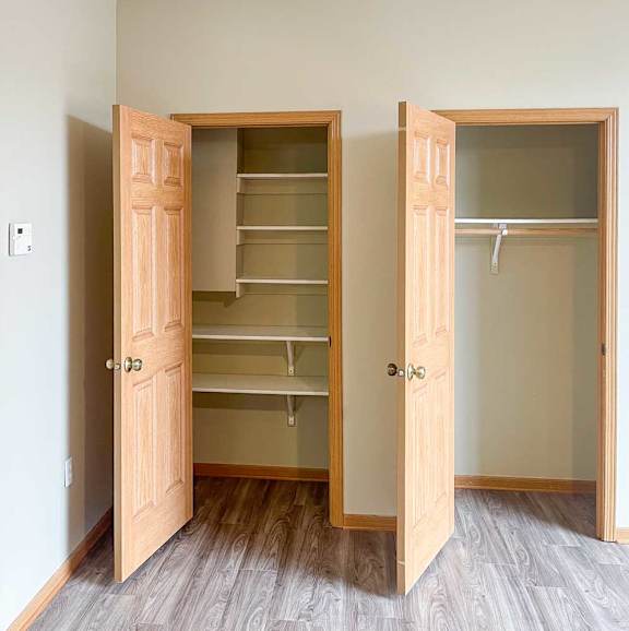 a pantry with built-in shelves next to a closet with built-in hanging space