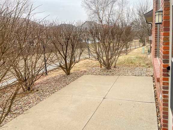 a concrete patio surrounded by bushes for extra privacy