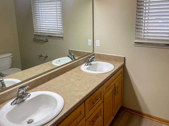 a bathroom with two sinks and a large mirror