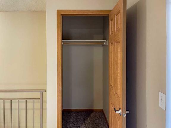 a closet in the living room with a built-in shelf and hanging bar