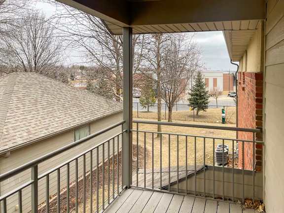 a balcony with a metal railing and a brown awning