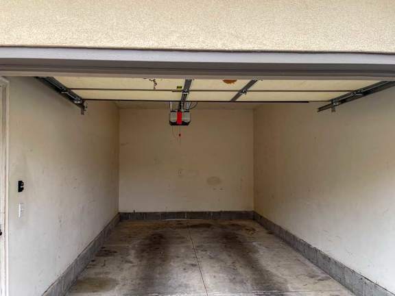 a garage with a white door and a concrete floor