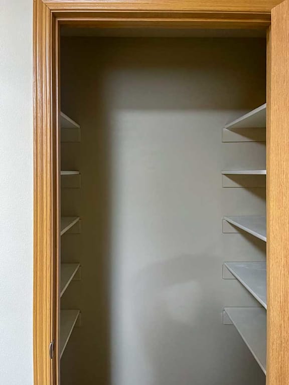 a wooden pantry with shelves and a door