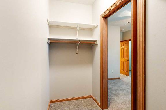 A walk-in closet with built-in shelves.