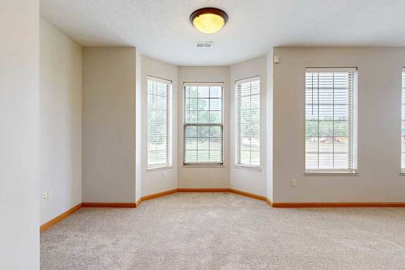 A dining room off a living room with a bay window.