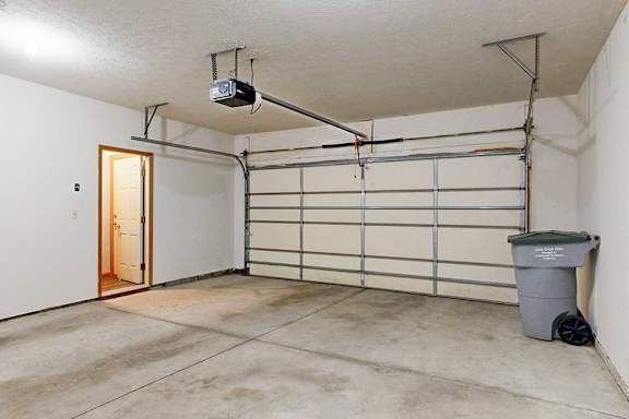 A 2-car attached garage with a private garbage bin, and a door to the apartment.