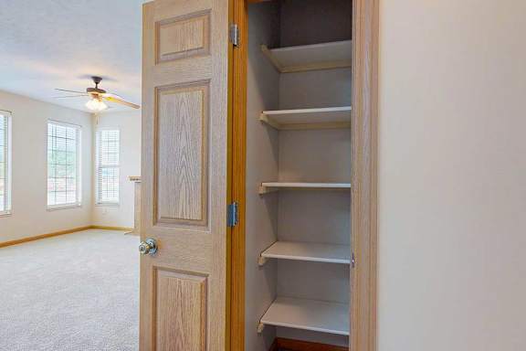 A hall closet with several built-in shelves.