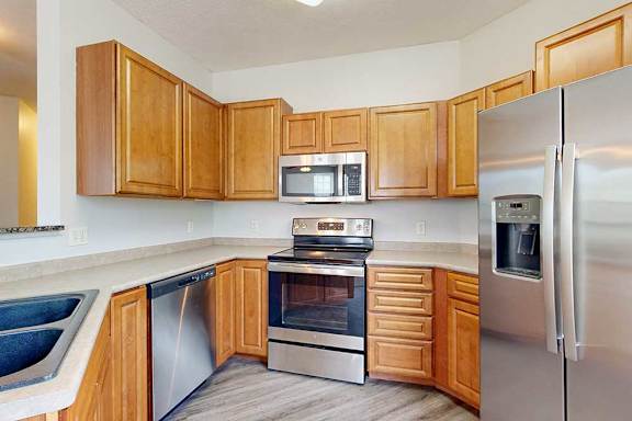 A kitchen with wooden cabinets and stainless steel appliances.