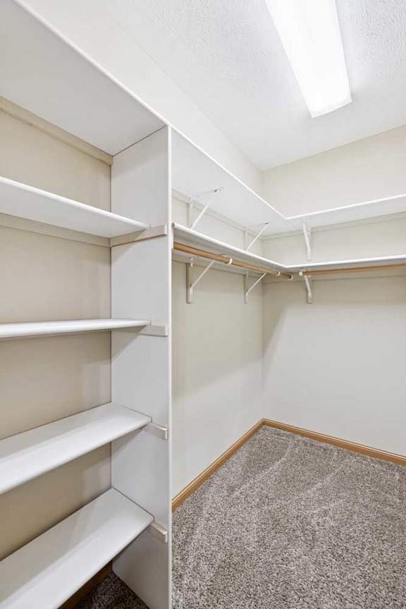 Spacious walk-in closet with built-in shelving and double hanging rods.