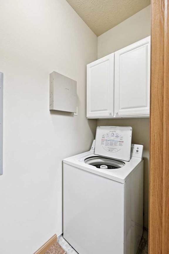 A white washing machine in a small laundry room.