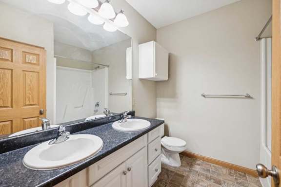 A bathroom with two sinks and a toilet.