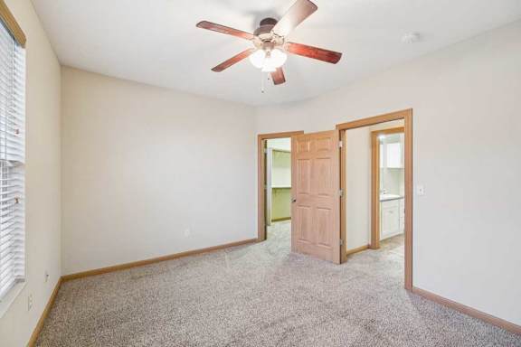 A room with a ceiling fan and a door.