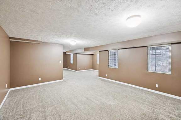 Basement family room featuring wide open floor plan and bright overhead lighting.
