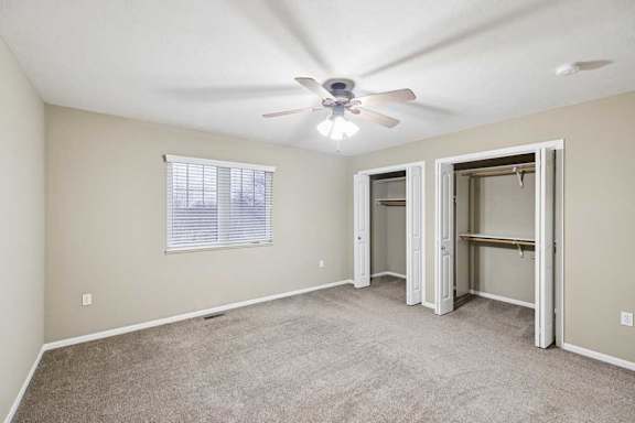 Kitchen with peninsula bar seating, oven and microwave, side-by-side refrigerator, and window for natural light.