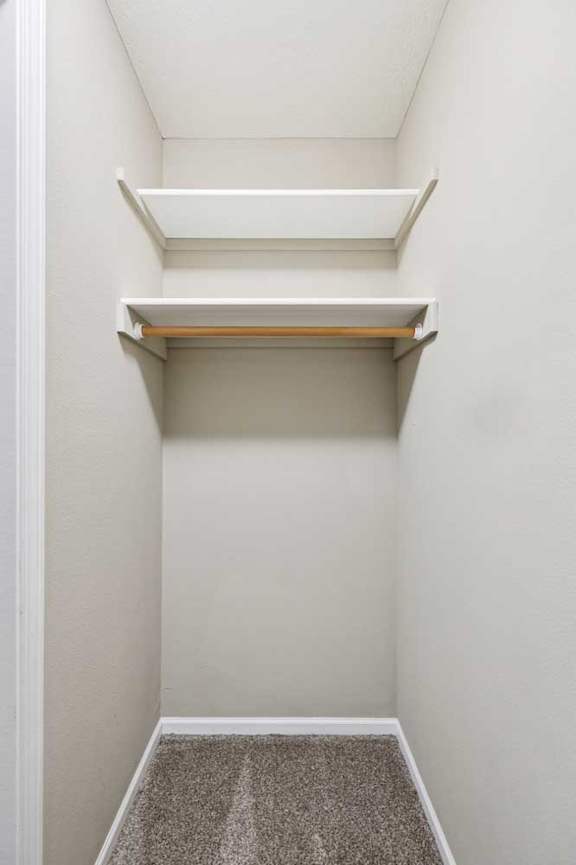 Walk-in closet with built-in shelving and hanging rod.