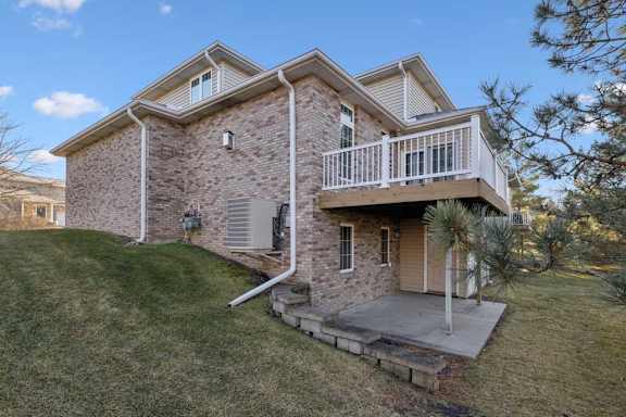 Rear exterior with brick façade, elevated deck, and covered patio below.