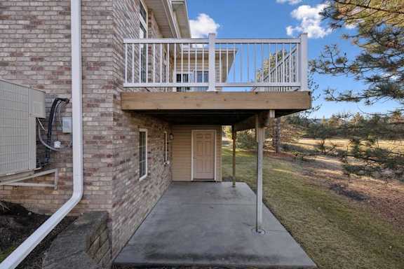 Covered lower-level patio with concrete slab and backyard views.
