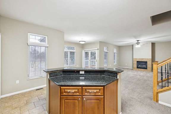 Open living and dining area with large windows, sliding glass door to deck, and corner fireplace.