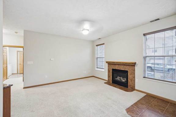 Living area with corner fireplace, large windows, and open layout connecting to dining space.