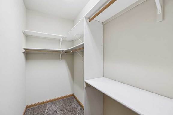 Walk-in closet with built-in shelving, hanging rods, and additional storage space.