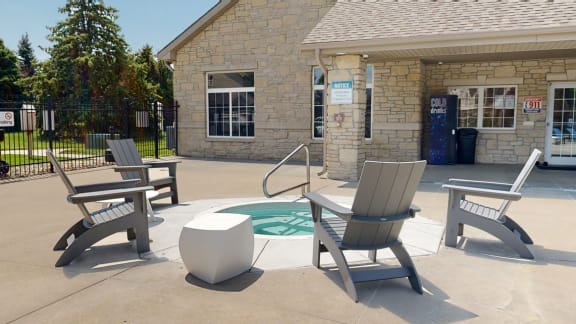 Lounging chairs surrounding a hot tub behind the community clubhouse