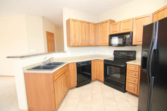 a kitchen with black appliances and wooden cabinets