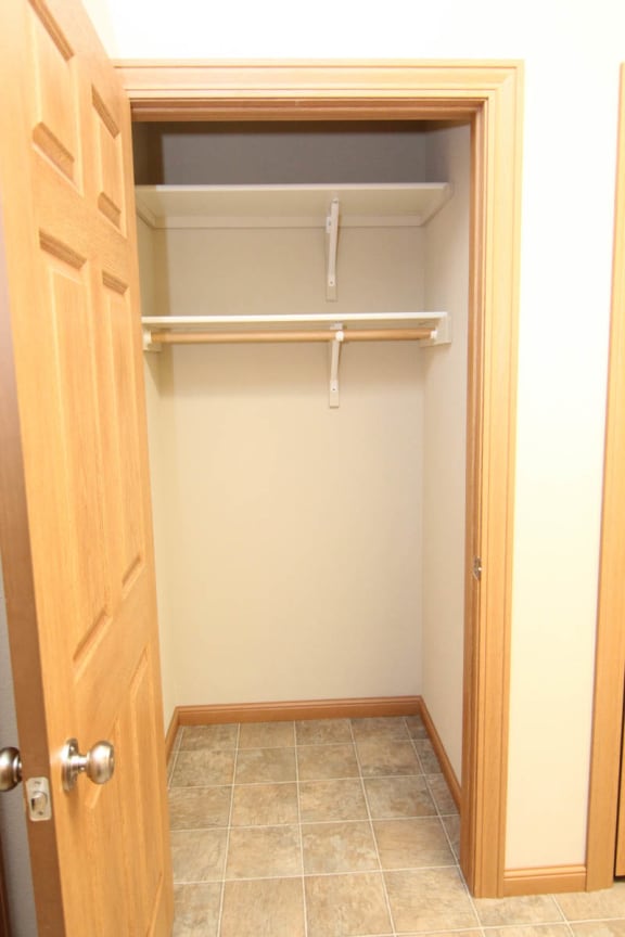 an empty closet in a bathroom with a door