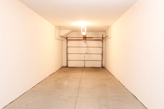an empty garage with a white wall and a white garage door