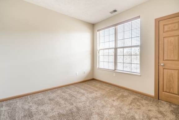 an empty room with a window and a door