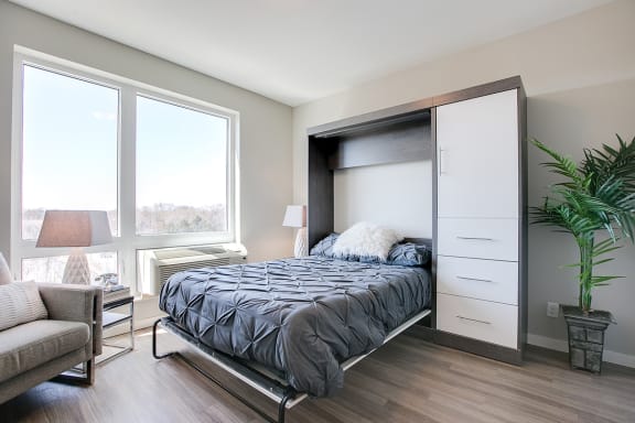 a bedroom with a bed and a large window
