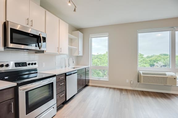 Kitchen with upper and lower cabinets against one wall with stainless steel appliances