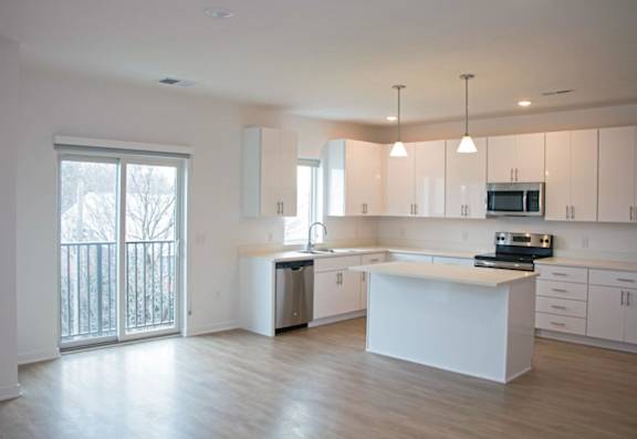 A kitchen with white cabinets and a large island.