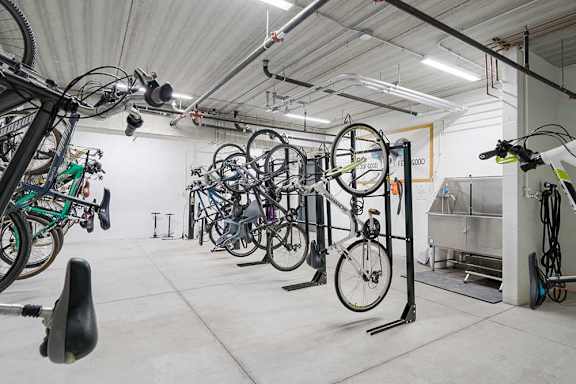 a bike locker room with multiple mounted spaces to hang bikes, and a built-in pet wash station