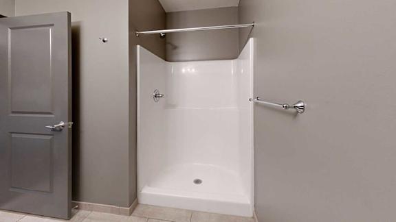 a bathroom with a walk in shower and a towel rack