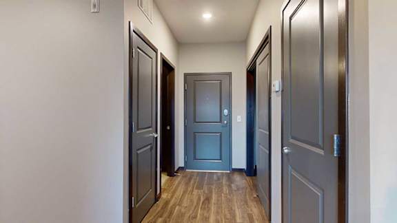an entry hallway with access to the bathroom, laundry, and closets