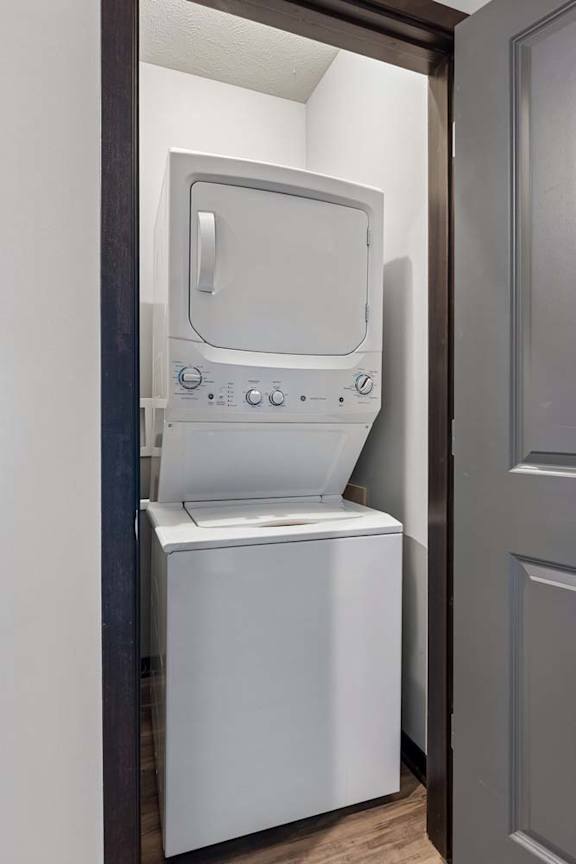 Dedicated in-home laundry closet with a stacked washer and dryer, tucked behind a dark-trimmed interior door.